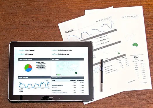 アクセス解析レポートを表示したタブレットと資料
