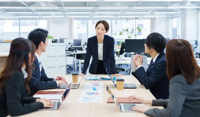 会議室でデータを確認しながら打ち合わせを行うビジネスチーム