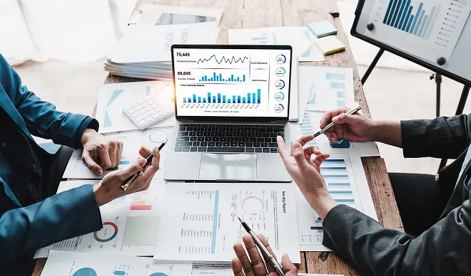 ノートパソコンの画面を見ながらUI設計を議論している様子