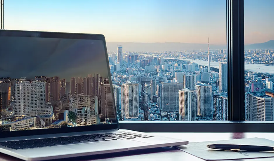ノートパソコンと都市風景が映るデスクワークのイメージ