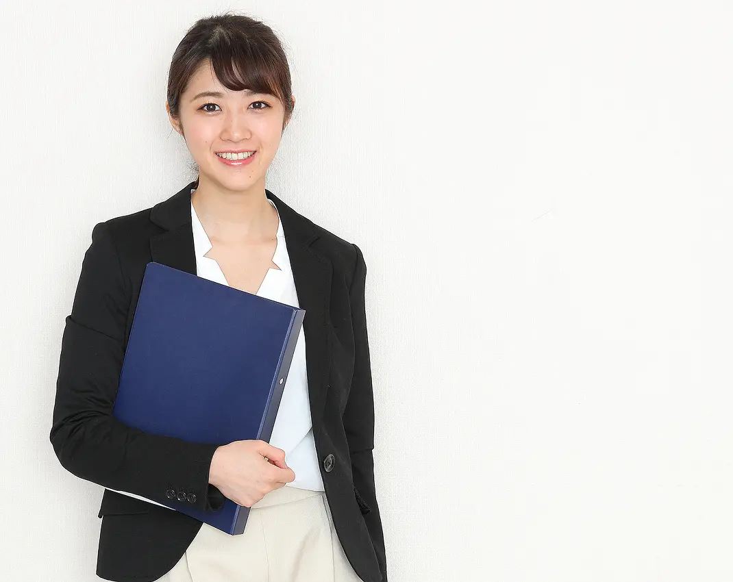 資料を持つ女性ビジネスパーソンのポートレート