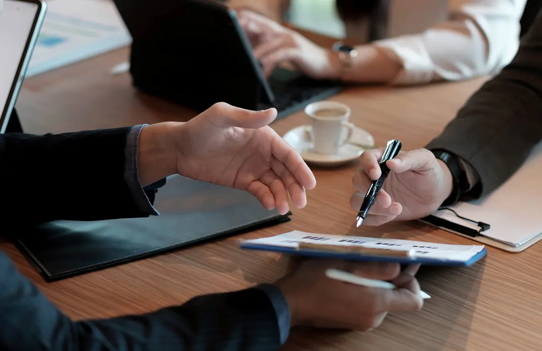打ち合わせ中に資料へ書き込みをしているビジネスシーン