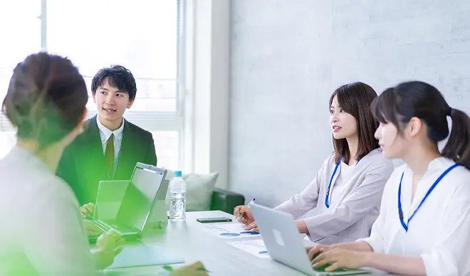 ノートパソコンを囲んでWebサイト制作について相談している様子