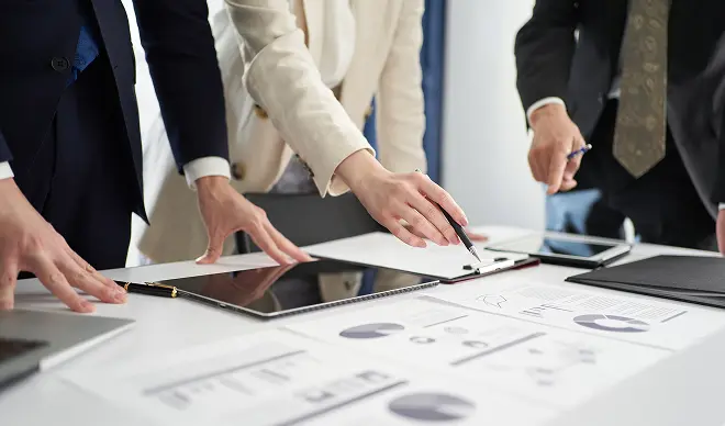 資料とタブレットを使い成果データを確認している様子