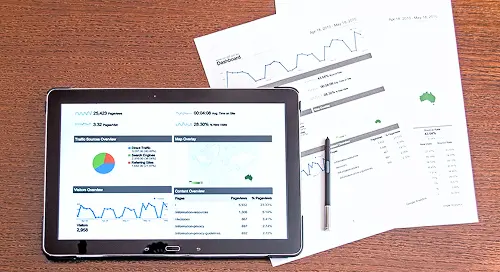 タブレットと資料を並べてアクセスデータを確認しているデスク風景